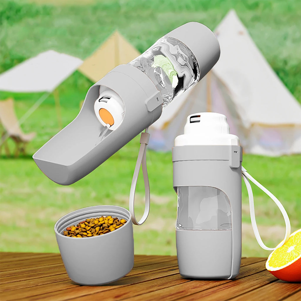 Grey 2-in-1 portable dog water bottle with attached food container, shown outdoors with kibble