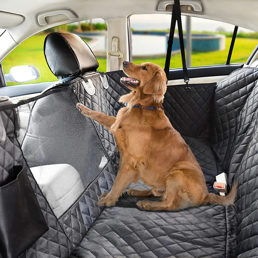 Golden retriever sitting on a black quilted waterproof dog car seat cover with mesh window in a back seat